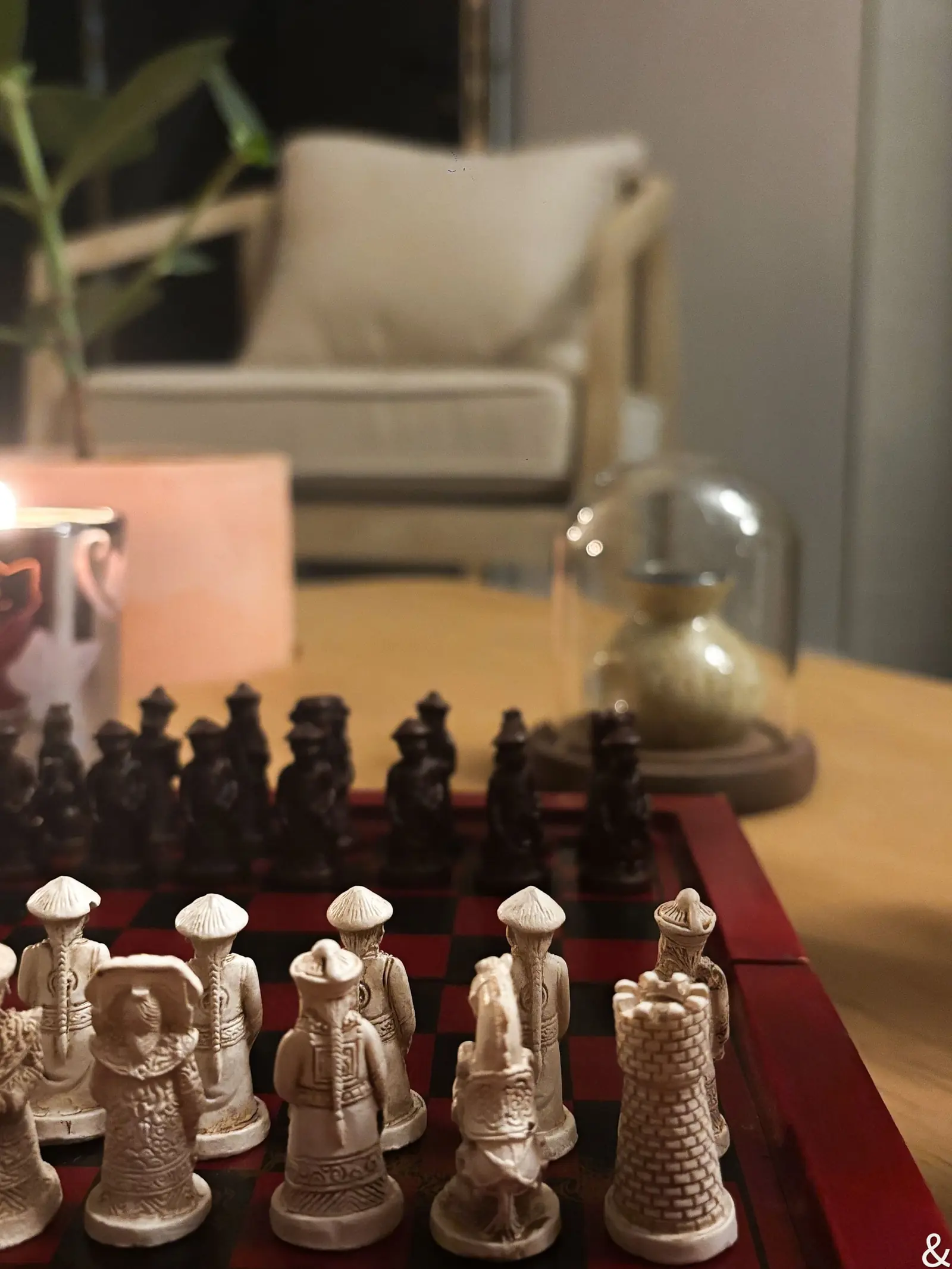 Jeu d’échecs en bois et lampe globe sur la table basse